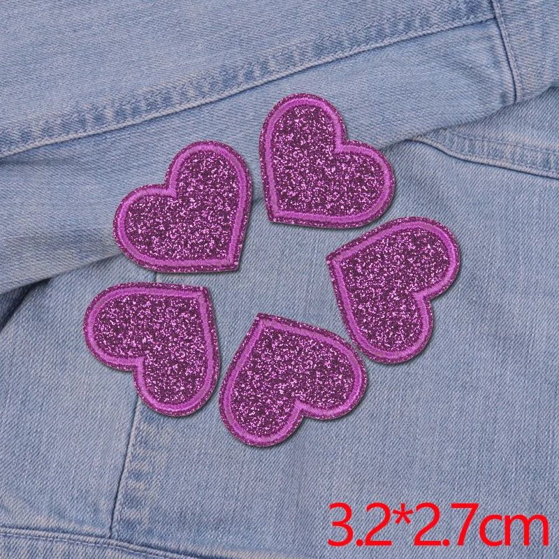 Five glitter iron-on embroidered love heart star patches on a denim fabric.