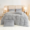 A plush gray duvet cover set displayed on a bed with upholstered headboard and bedside lamps.