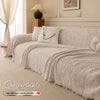 A beige herringbone chenille sofa cover draped over a light-colored sofa with decorative pillows.