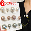 A set of six pearl brooch jewelry pieces displayed on a white card against a black background.