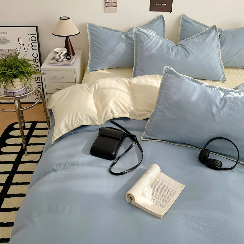 A light blue bed with white and gray pillows, featuring a luxurious washed cotton linen set.