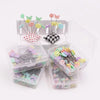 A bulk set of colored sewing pins for crafting displayed in clear plastic containers and a cardboard holder.