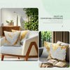A golden white decorative throw pillow cover with wing patterns on a white sofa.
