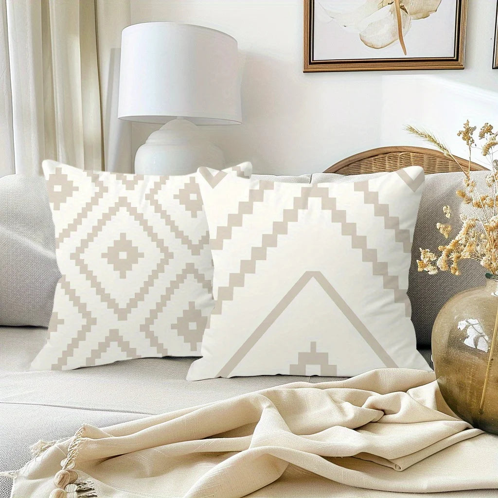 A close-up of a white decorative pillow cover with a geometric pattern on a light gray sofa.