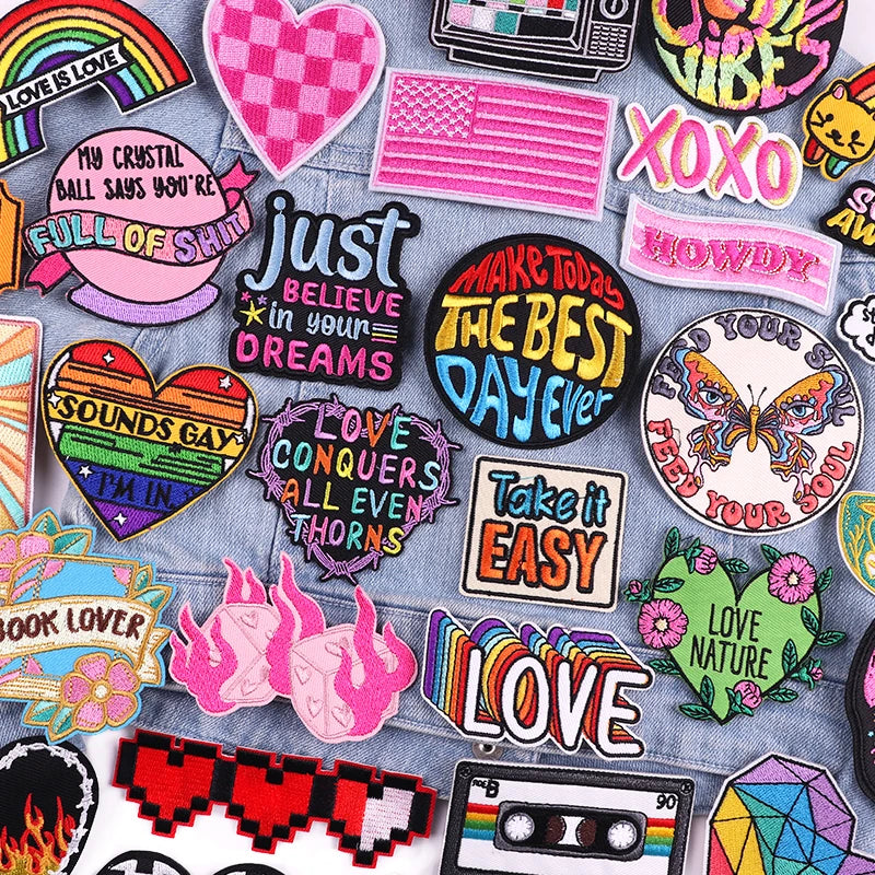 A collection of colorful embroidered letter patches featuring words like LOVE, XOXO, and various phrases for jackets and clot