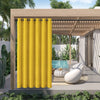 A bright yellow waterproof outdoor curtain with a grommet top hanging in a wooden pergola setting.