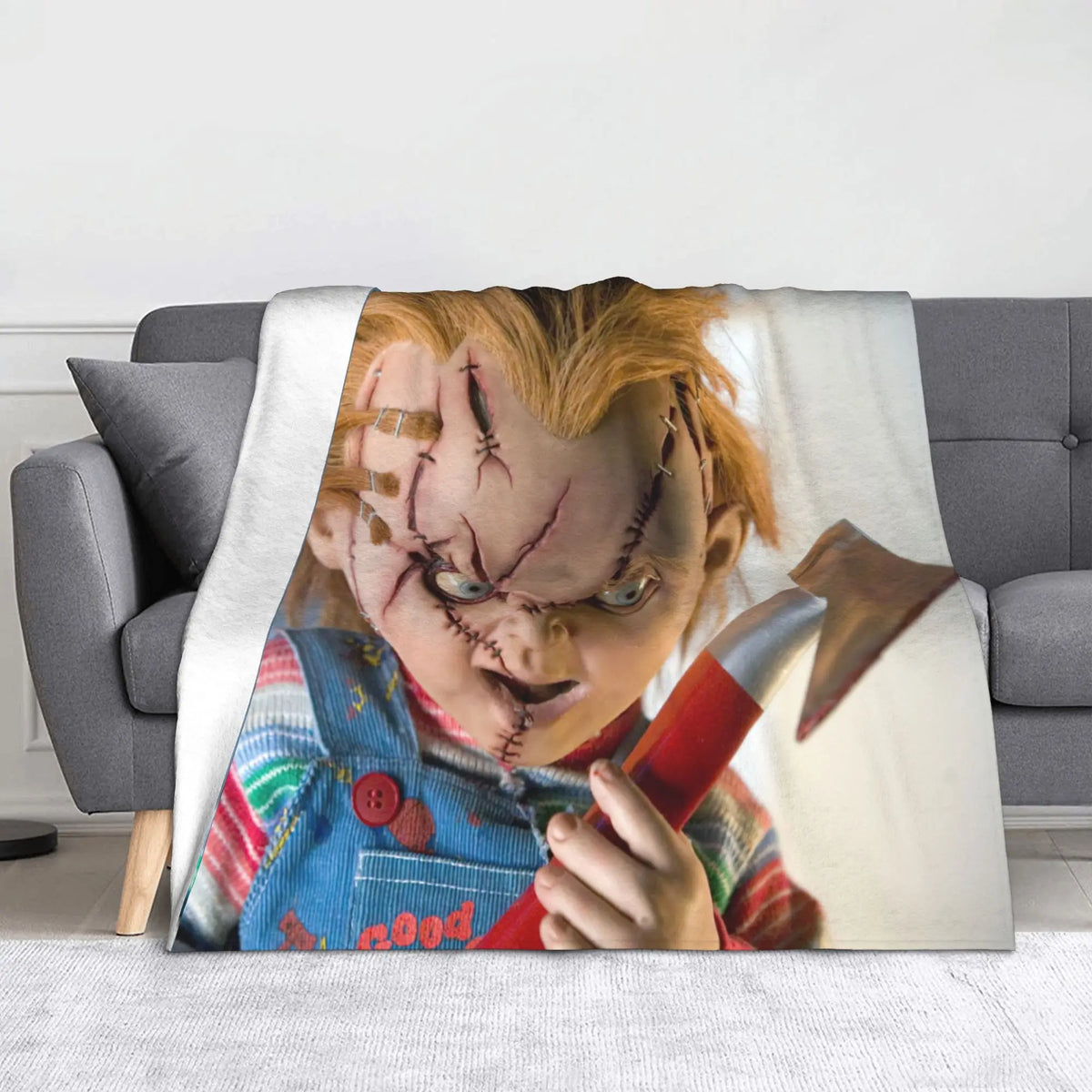 A throw blanket featuring a graphic of Chucky with facial injuries and a knife.