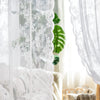 White floral lace sheer curtain hanging in a bright room