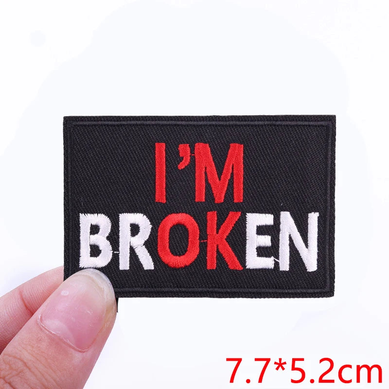 Black embroidered patch with the text I'M BROKEN in red and white letters