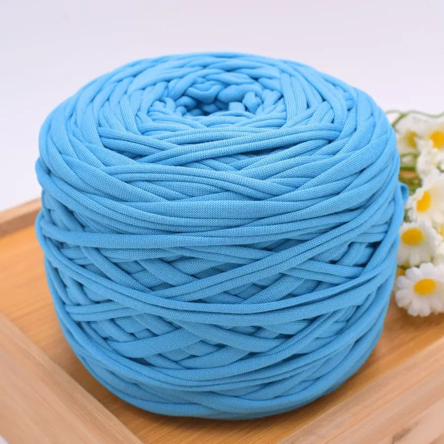 A ball of bright blue craft yarn for knitting and DIY displayed on a wooden surface.