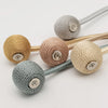 A set of minimalist magnetic ball curtain tiebacks in various shades of beige and gray.