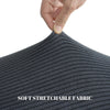 Hand touching a dark gray soft stretchable fabric material.