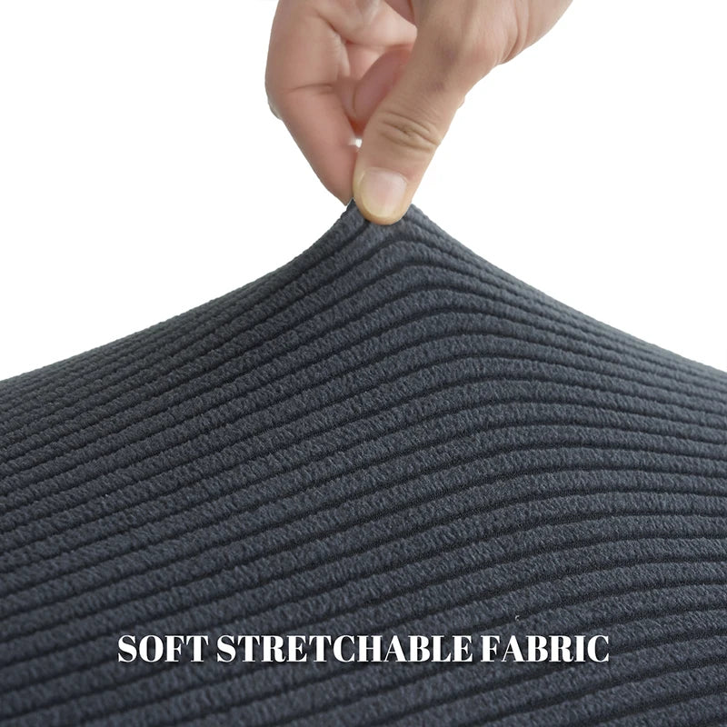 Hand touching a dark gray soft stretchable fabric material.