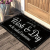 A black laundry mat with white text that reads Wash & Dry or be naked tomorrow, placed on a wooden floor.