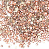 A close-up view of a mix of clear and rose gold glass rhinestones for DIY crafts.