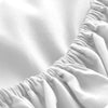 Close-up of a white fitted mattress protector sheet with gathered fabric texture.