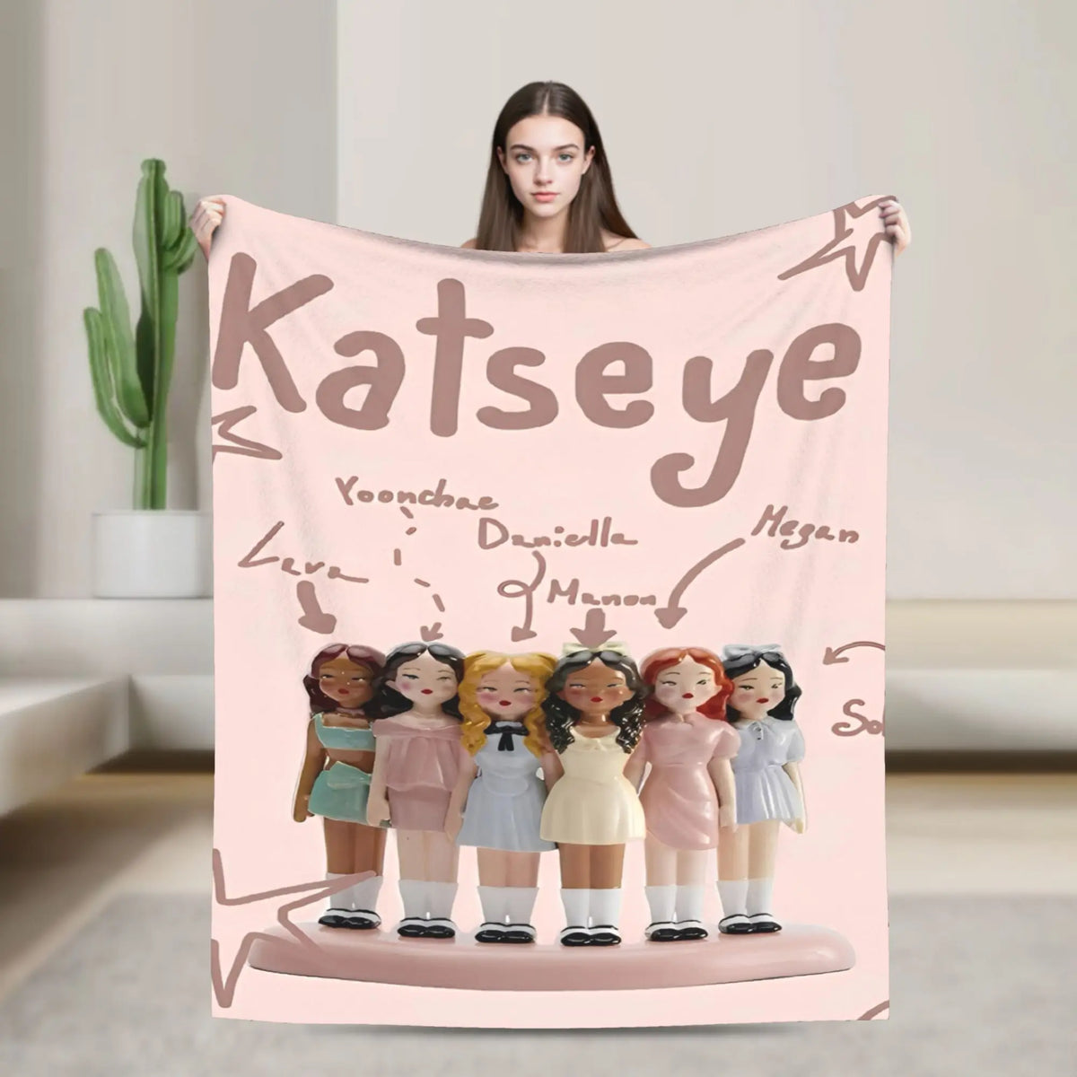A pink fleece throw blanket featuring illustrations of K-Pop idols and a star design.