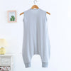 A light blue and white striped cotton sleeping bag for children hanging on a wooden hanger.