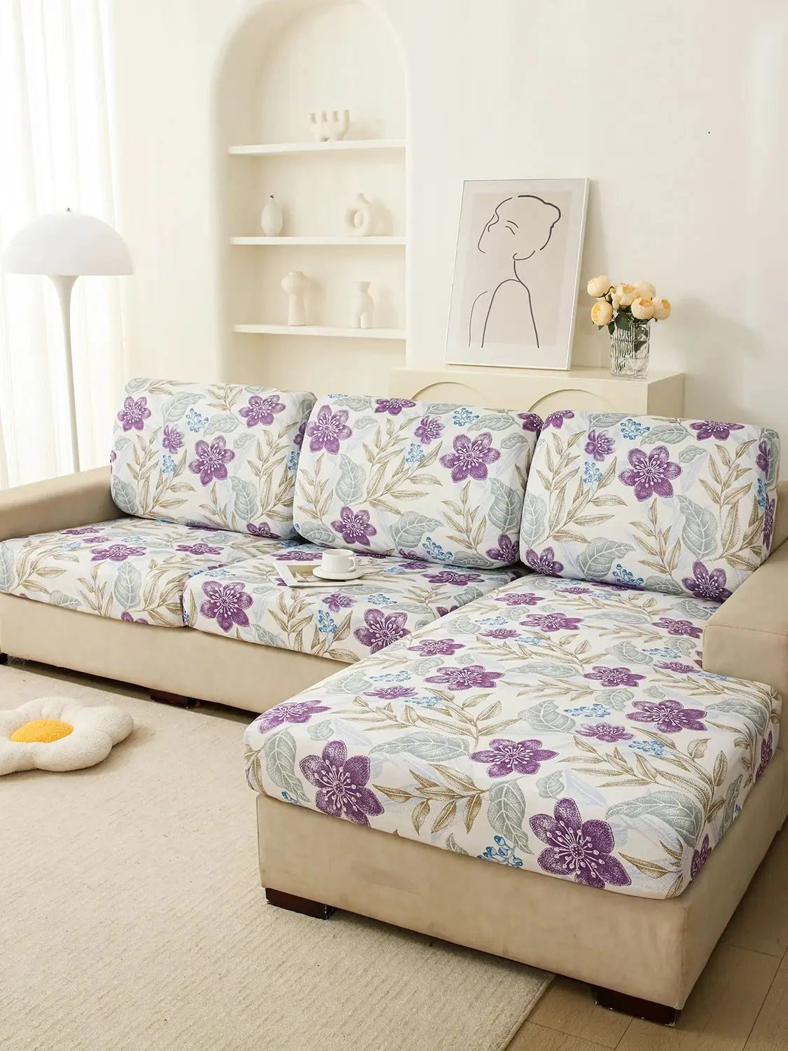 A floral print elastic sofa protective cover featuring purple and green leaves on a beige sofa.