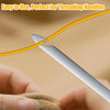 A stainless steel needle threader is shown piercing a yellow thread, being used for hand sewing or embroidery.