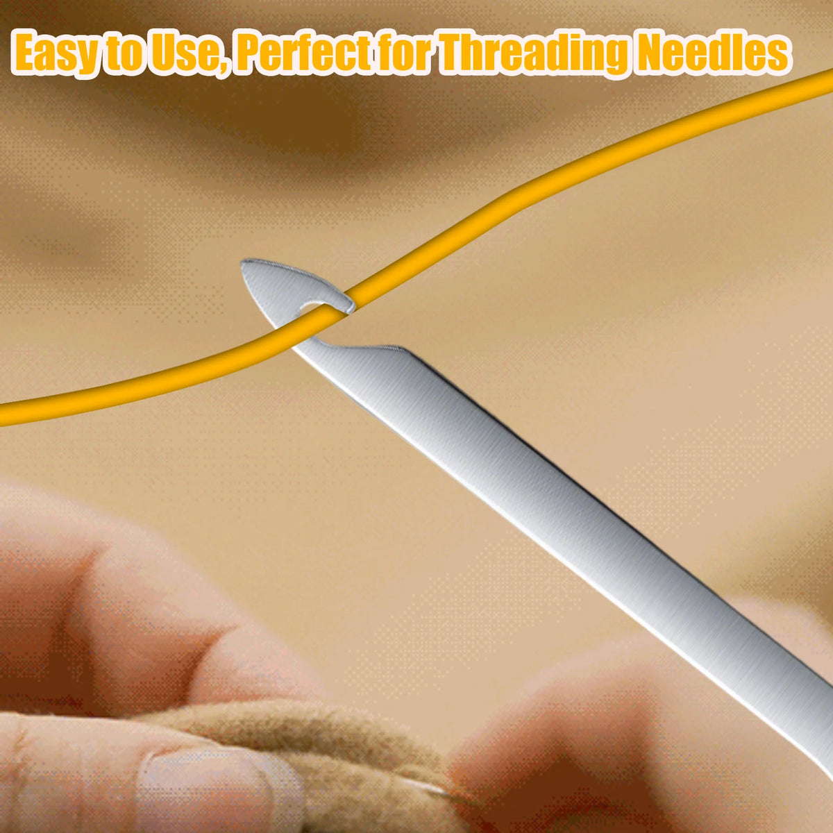 A stainless steel needle threader is shown piercing a yellow thread, being used for hand sewing or embroidery.