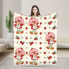 A woman is holding a strawberry shortcake plush throw blanket featuring cute characters and strawberries on a light backgroun