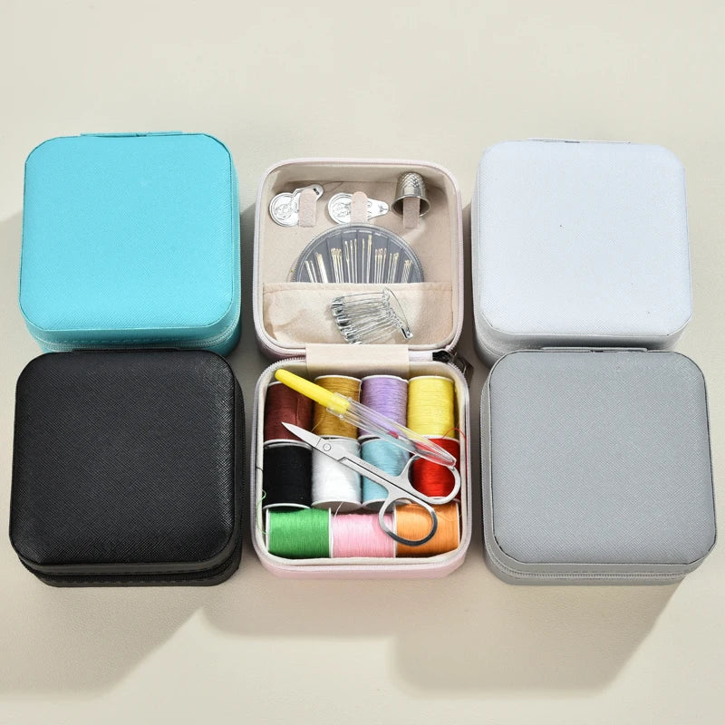 A collection of four square sewing boxes in blue, pink, white, and gray, each containing various hand sewing tools.