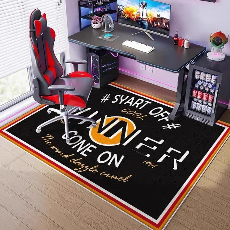 A black gaming area rug with neon orange text and a white border placed in front of an office desk.