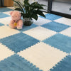 A blue and white diamond patterned rug mat with a pink plush toy and a potted plant on a glass table.