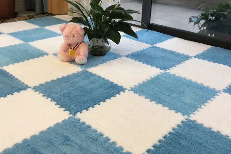 A blue and white diamond patterned rug mat with a pink plush toy and a potted plant on a glass table.