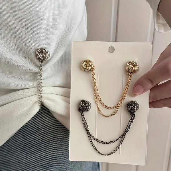A hand holds a white magnetic chain buckle accessory against a white shirt and denim fabric.