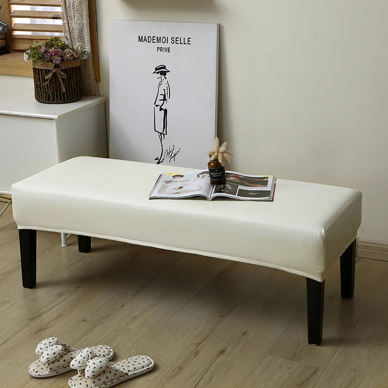A beige waterproof stretch dining bench cover is displayed on a white bench in a bright room.