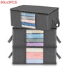 Three stacked gray storage bags with visible layers of light blue, pink, and purple fabric inside