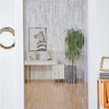 Decorative door string curtains covering a window with sheer white strands and a light wood floor.