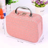 A pink quilted portable sewing kit box with a silver handle and storage for needles and thread.