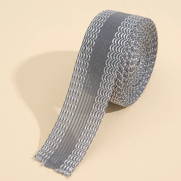 Roll of silver self-adhesive hem tape for fabric repair and shortening