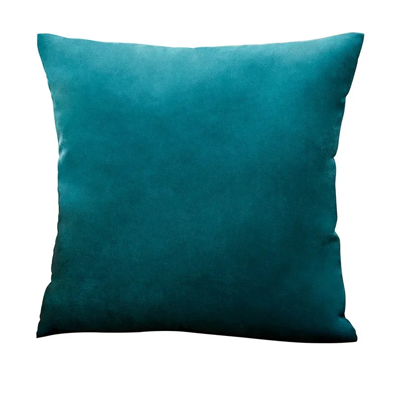 A deep teal velvet throw pillow cover resting on a white background.