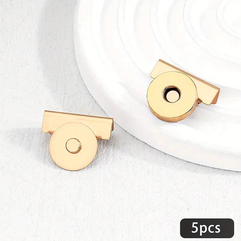 Five gold-toned metal seamless magnetic closure buckles displayed on a white background.