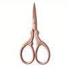 A pair of rose gold embroidery scissors with pointed tips and curved handles.