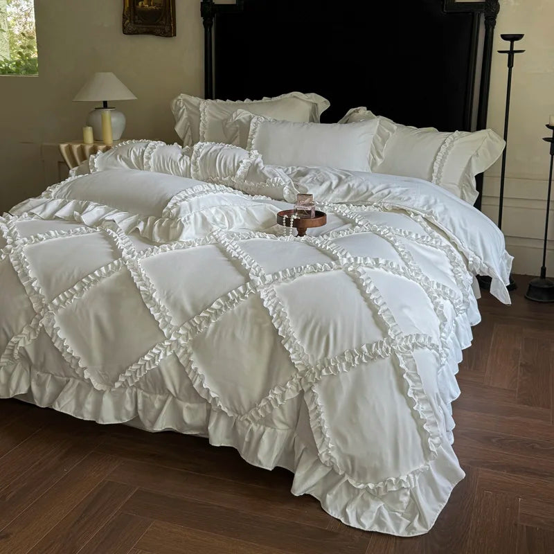 A white ruffled duvet cover set displayed on a bed with dark wood flooring and a black fireplace mantel.