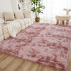 A pink shaggy rug is placed on a wooden floor in a bright living room setting.