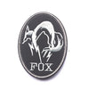 A black embroidered patch featuring a silver silhouette of a fox head with lightning bolts and the text FOX.