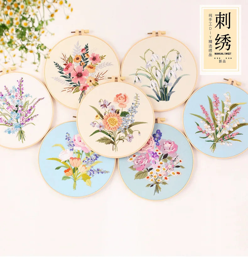 A collection of round embroidery kits featuring various floral patterns and botanical designs on light fabric.