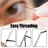 Close-up of a stainless steel sewing needle being used for threading fabric.