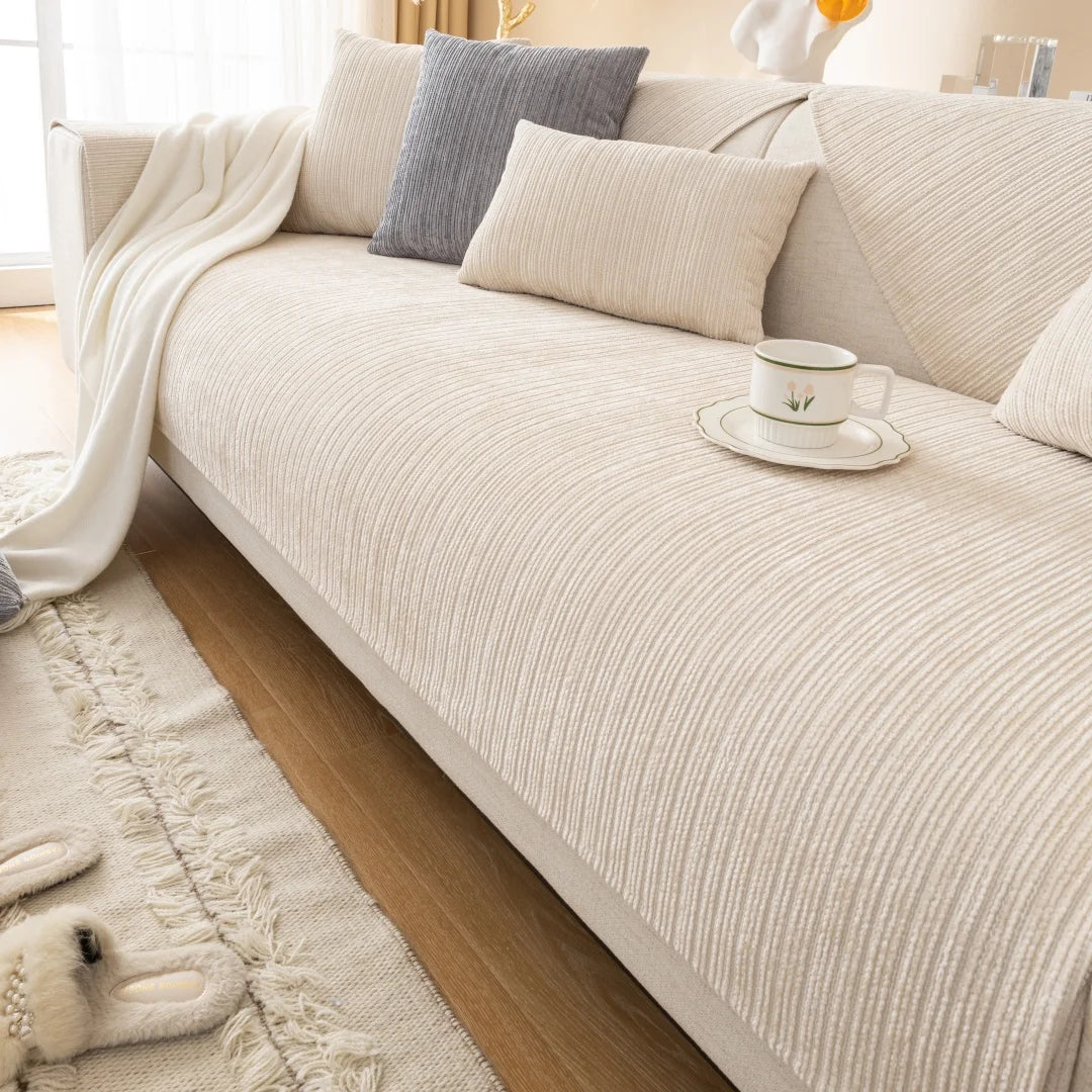A beige chenille sofa cushion cover with light gray and cream accent pillows on a sofa.