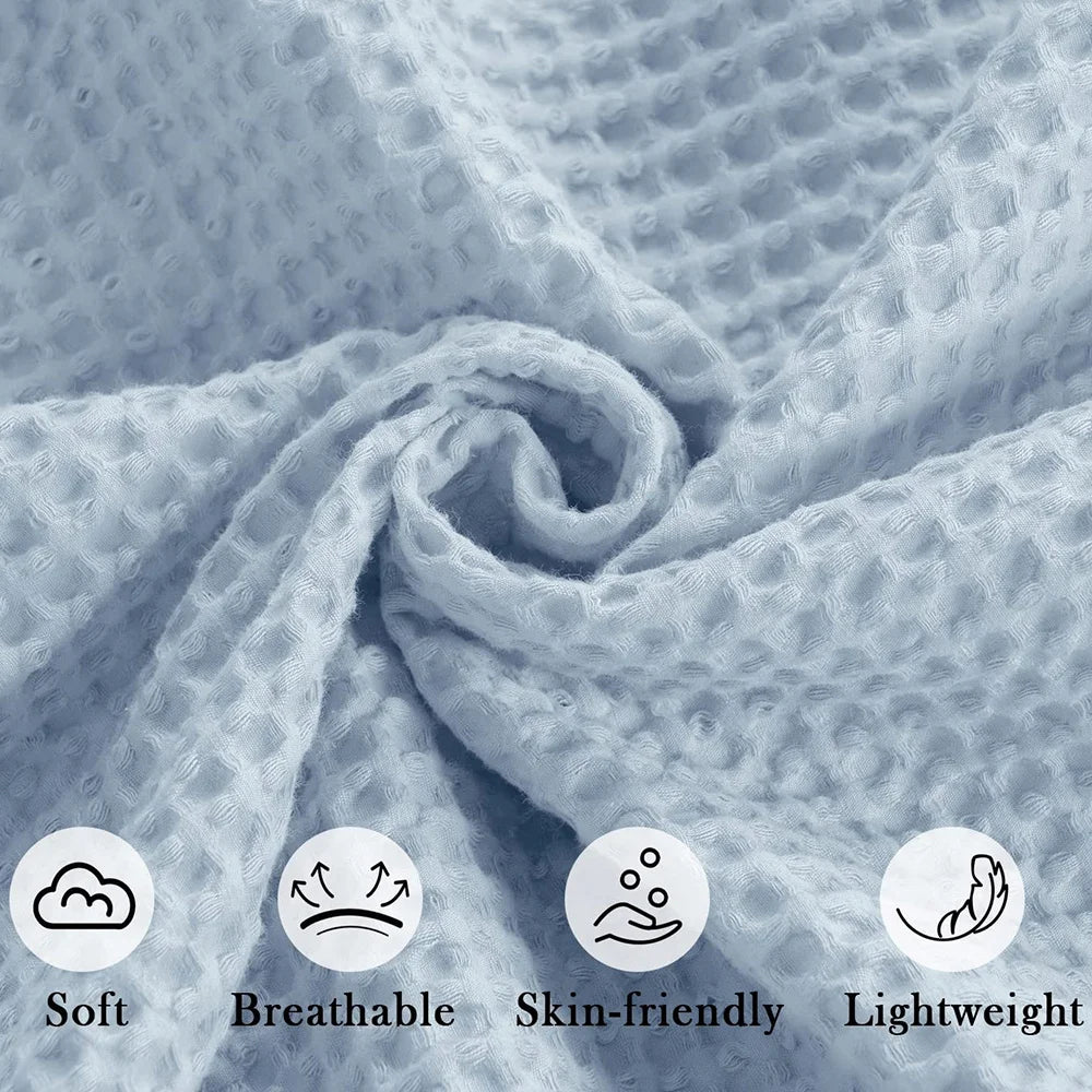 A close-up of a soft, light blue waffle knit blanket folded in a swirl.