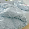 A light blue soft textured duvet cover set with matching pillowcases on a bed.