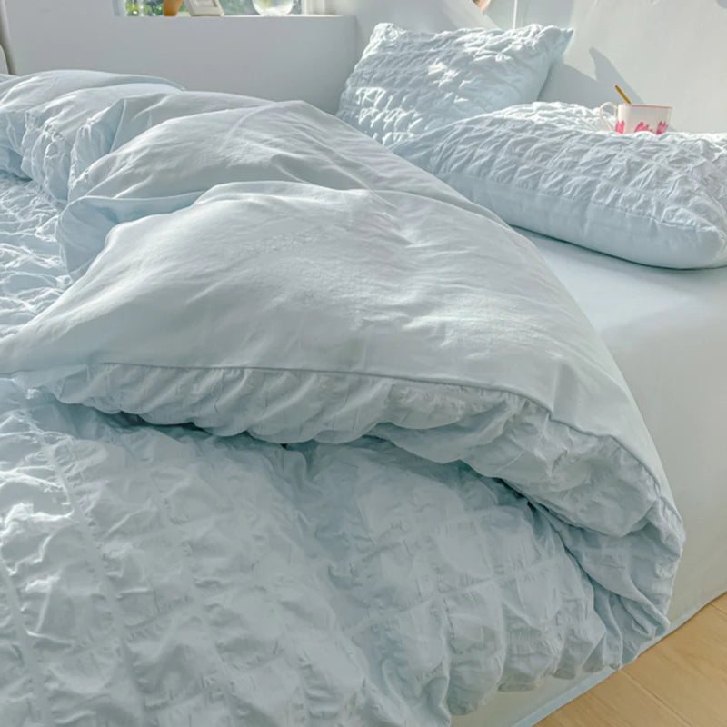 A light blue soft textured duvet cover set with matching pillowcases on a bed.