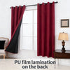 A pair of deep red curtains with black accents hanging in a window frame.