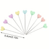 A set of ten heart-shaped sewing pins in pastel colors, including pink, purple, yellow, and mint green.